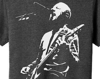 May include: A white silhouette of a person singing and playing a guitar on a dark gray t-shirt.