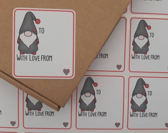 May include: A sheet of white gift tags with a red border and a cartoon gnome illustration. The tags have the text "TO" and "WITH LOVE FROM" printed on them.