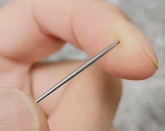 May include: A close-up of a finger with a small, thin, silver needle inserted into it.