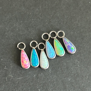 Può includere: Sei ciondoli a forma di lacrima in opale di vari colori, tra cui rosa, blu, bianco, verde e viola, sono attaccati ad anelli a salto d'argento.