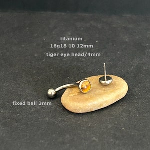 May include: Titanium body jewelry with a tiger eye gemstone. The jewelry is 16 gauge and comes in 10mm, 12mm lengths. The tiger eye head is 4mm and the fixed ball is 3mm.