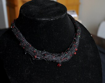 Collier multi-brins noir avec perles rouges et vertes