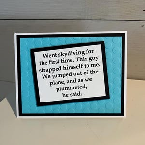 May include: A greeting card with a white border, black frame, and a turquoise background with a textured pattern. The card features the text: "Went skydiving for the first time. This guy strapped himself to me. We jumped out of the plane, and as we plummeted, he said:"