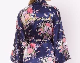 May include: A navy blue satin robe with a floral print and the word "Bridesmaid" embroidered on the back.