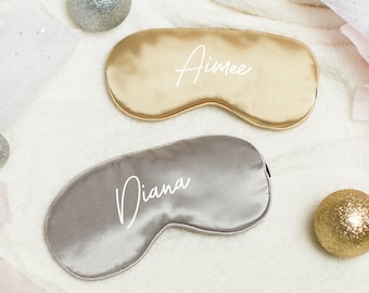 May include: Two satin sleep masks, one gold and one gray, with the names "Aimee" and "Diana" embroidered on them.