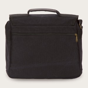 May include: A black canvas messenger bag with a brown leather handle and a zippered pocket on the front. The bag has a shoulder strap.
