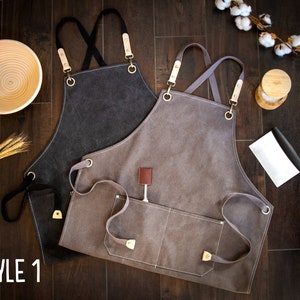 May include: Two canvas aprons with adjustable straps and multiple pockets. The apron on the left is dark gray and the apron on the right is light gray.