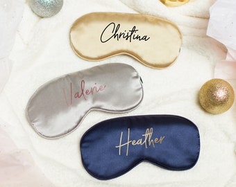 May include: Three satin sleep masks in different colors with personalized names: Christina, Valerie, and Heather. The masks are gold, silver, and navy blue.