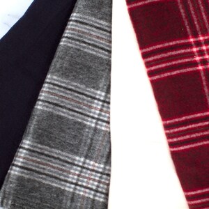 May include: Three fabric swatches, one navy blue, one gray with white and brown plaid, and one red with white plaid.