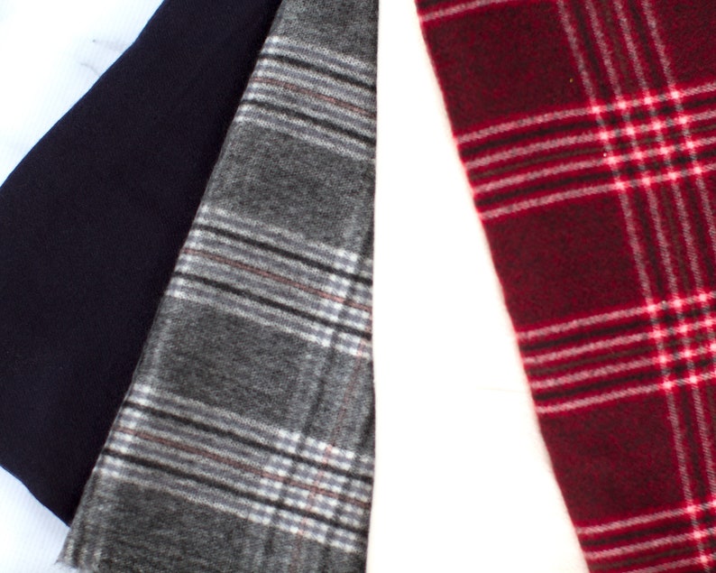 May include: Three fabric swatches, one navy blue, one gray with white and brown plaid, and one red with white plaid.