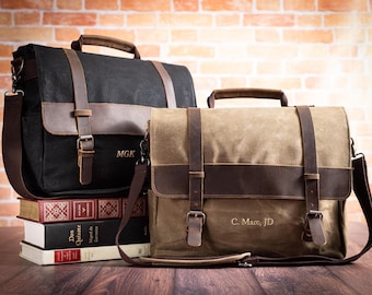 Könnte beinhalten: Zwei Messenger-Taschen aus Canvas und Leder mit personalisierten Initialen. Die Tasche links ist schwarz mit braunen Lederelementen und den Initialen "MGK". Die Tasche rechts ist beige mit braunen Lederelementen und den Initialen "C. Marc, JD".