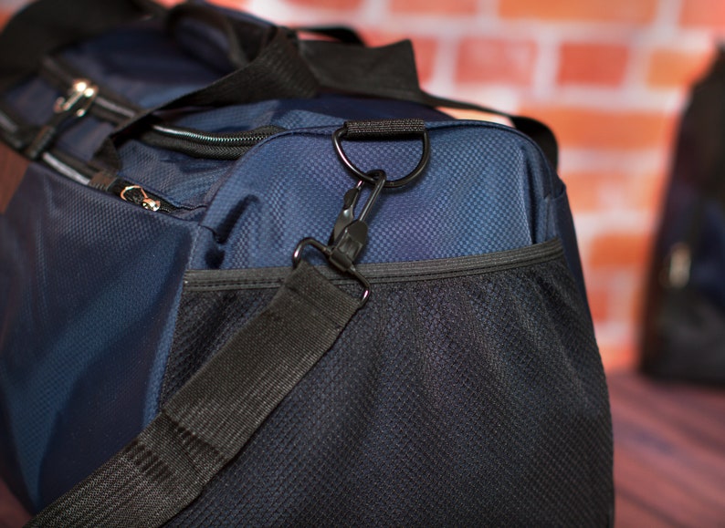 May include: A blue and black duffel bag with a zipped pocket and a black adjustable shoulder strap. The bag has a mesh pocket on the front.