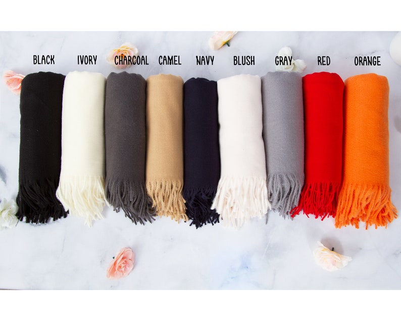 May include: Ten different colored scarves with fringe. The colors are black, ivory, charcoal, camel, navy, blush, gray, red, orange, and white.