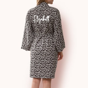 May include: A black and white leopard print robe with the name "Elizabeth" embroidered on the back in white.
