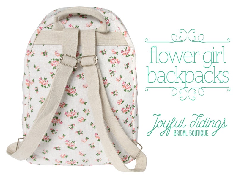May include: A white canvas backpack with a floral pattern. The backpack has adjustable straps and a zipper closure. The text "flower girl backpacks" and "Joyful Tidings BRIDAL BOUTIQUE" is visible in the image.