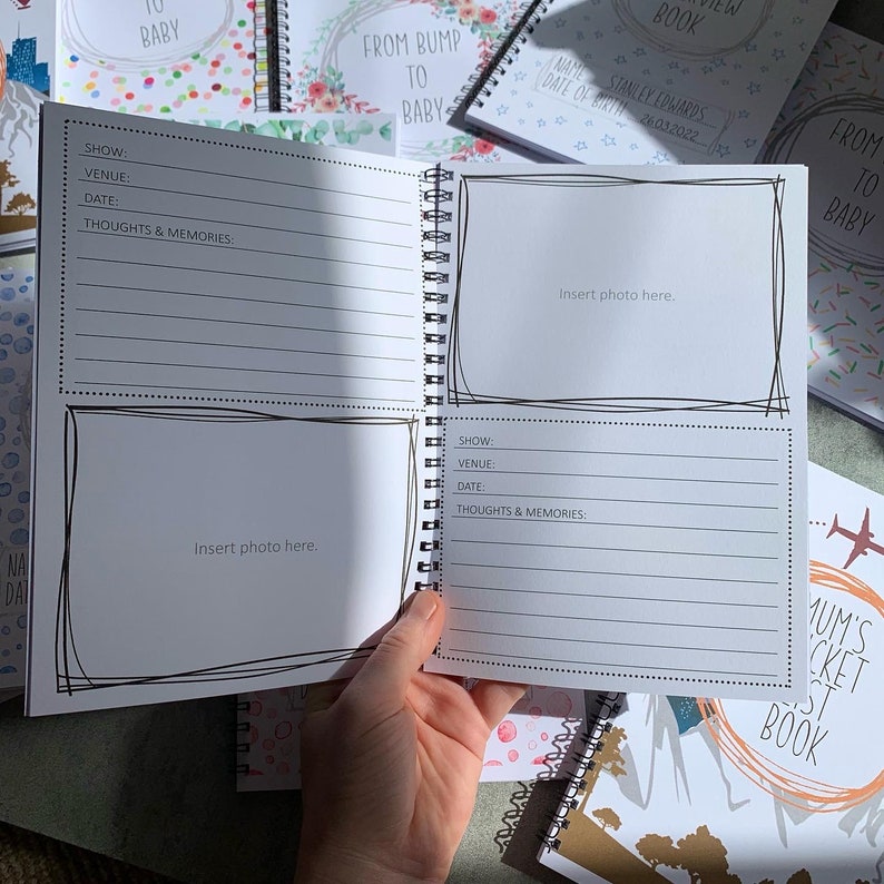 Puede incluir: Libro de recuerdos para beb&eacute;s con encuadernaci&oacute;n en espiral, con p&aacute;ginas rayadas y espacios para fotos. El libro se titula "From Bump to Baby". Otros libros en el fondo tienen dise&ntilde;os florales y de confeti. El libro est&aacute; abierto.