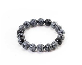 May include: A black and gray beaded bracelet with a snowflake obsidian pattern.