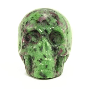 May include: Green and pink gemstone skull sculpture.