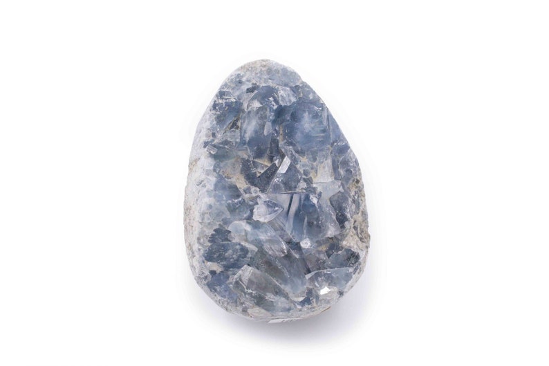 May include: A blue celestite crystal cluster with a rough, natural surface. The crystal is a light blue color and has a variety of shapes and sizes.