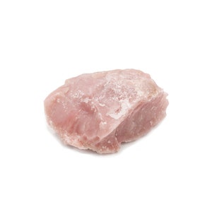May include: A close-up of a pink, irregularly shaped rock with a rough, textured surface.