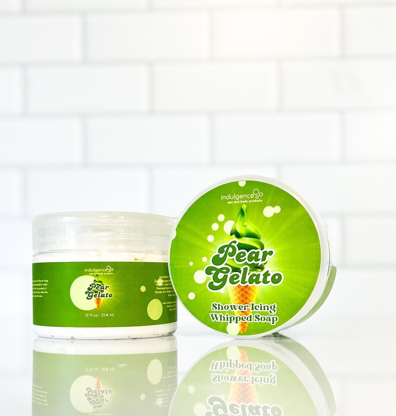 Pu&ograve; includere: Due barattoli di sapone montato profumato alla pera. I barattoli sono etichettati "Pear Gelato" e "Shower Icing Whipped Soap". I barattoli sono su uno sfondo di piastrelle bianche.