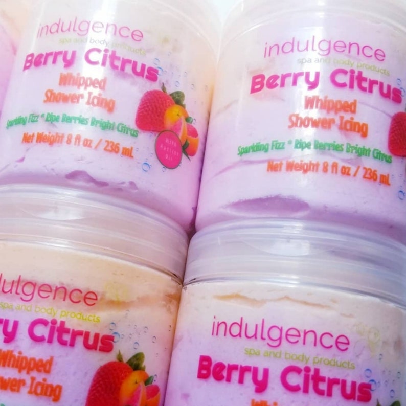Pu&ograve; includere: Quattro barattoli di plastica rosa e bianchi di glassa per doccia montata con un profumo di frutti di bosco e agrumi. I barattoli hanno un'etichetta che dice "indulgence spa and body products Berry Citrus Whipped Shower Icing Sparkling Fizz Ripe Berries Bright Citrus Net Weight 8 fl oz / 236 ml".