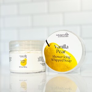 Pu&ograve; includere: Un barattolo bianco con un design a pera gialla e il testo "Vanilla Pear Shower Icing Whipped Soap" sull'etichetta. Il barattolo contiene un sapone montato bianco. Il barattolo &egrave; da 12 once liquide o 354 grammi.