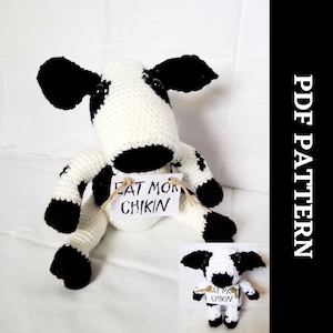Könnte beinhalten: Häkelanleitung für ein Amigurumi aus schwarzem und weißem Garn, das ein Schild mit der Aufschrift "Eat Mor Chikin" hält.