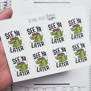 May include: A sheet of stickers featuring a cartoon alligator wearing pink sunglasses. The stickers have the text "SEE YA LATER" in black, with a small star graphic. The brand name "BEYOND PAPER flowers" is at the top.