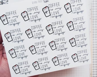 Può includere: Un foglio di adesivi con la scritta "COFFEE is my LOVE language" e un disegno di una tazza di caffè. Gli adesivi sono in bianco e nero con un coperchio rosso, su un quaderno a quadretti.