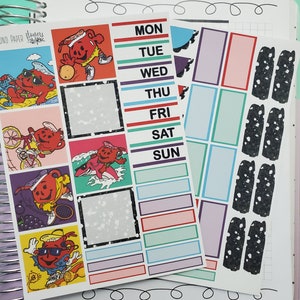 May include: A set of colorful planner stickers featuring a cartoon character with a red cup and various activities. The stickers include a daily planner, a weekly planner, and a set of decorative stickers with a black and white speckled design.
