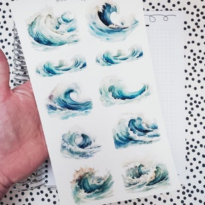 May include: A sheet of stickers featuring watercolor illustrations of ocean waves in shades of blue and white. The stickers are designed by Beyond Paper Flowers.