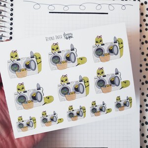May include: A sheet of stickers featuring cartoon illustrations of green worms doing laundry. The stickers are printed with the text "Beyond Paper Flowers".