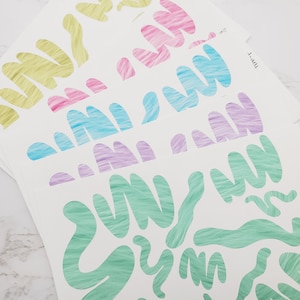 May include: Four sheets of white paper with different colored abstract shapes. The shapes are filled with a textured pattern and are in shades of green, blue, pink, and yellow.