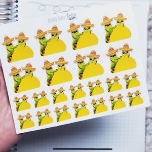 May include: A sheet of stickers featuring cartoon tacos and avocados wearing sombreros. The stickers are yellow, green, and brown, with the text "BEYOND PAPER" visible. The stickers are on a white background.