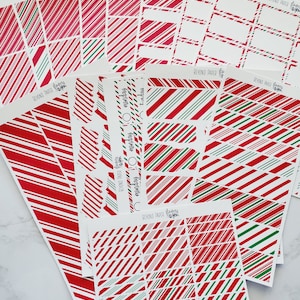 May include: A set of 10 printable planner stickers featuring a red and green candy cane stripe pattern. The stickers are designed for use in a planner or journal and include various sizes and shapes.