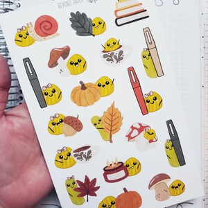 May include: A sheet of planner stickers featuring fall-themed illustrations. The stickers include pumpkins, mushrooms, leaves, and cute yellow characters. The text "BEYOND PAPER planners" is visible at the top.
