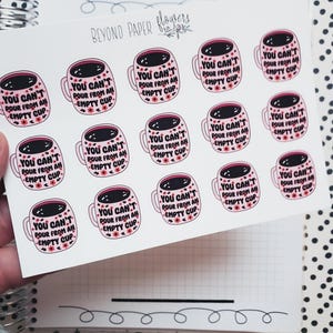 May include: A sheet of stickers featuring pink coffee mugs with the text "YOU CAN'T POUR FROM AN EMPTY CUP." The mugs have a dark brown coffee design and small pink flowers. The stickers are on a white background.