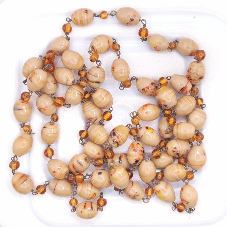 Fabulous long glass dark cream coloured bead Art Deco necklace. The beads were most probably made in Murano Italy. In fabulous condition with no damage that I can see.
42" long