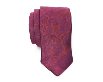 May include: A burgundy silk tie with a subtle, abstract pattern in a lighter shade of burgundy.