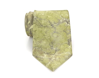 May include: A green tie with a marbled pattern. The tie is a light green color with darker green and brown swirls throughout. The tie is rolled up at the top and angled down towards the bottom.