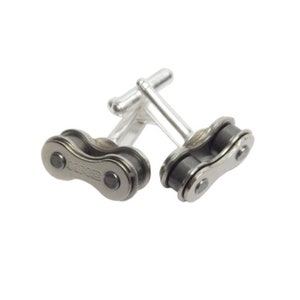 May include: A pair of silver cufflinks with a black bike chain design. The chain links are connected to the cufflink backs.