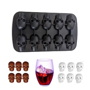 May include: Black silicone skull ice cube tray with 12 individual skull molds. The tray is filled with ice cubes and a glass of red liquid with ice cubes is in the background.