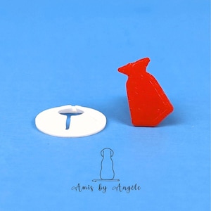 May include: A white plastic cookie cutter shaped like a tie, and a red plastic cookie cutter shaped like a tie.