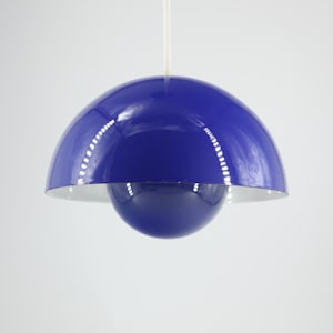 Puede incluir: Una lámpara colgante azul con una pantalla en forma de cúpula y una esfera más pequeña que cuelga debajo. La lámpara está hecha de metal y tiene un acabado brillante.