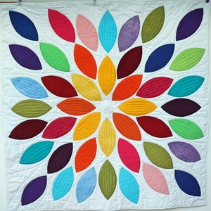 Pu&ograve; includere: Un quilt colorato con un design circolare di forme di foglie sovrapposte in tonalit&agrave; di rosso, arancione, giallo, verde, blu, viola e rosa.