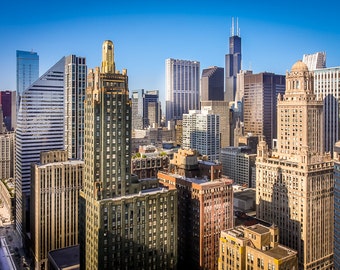 May include: An aerial view of a cityscape with tall buildings, including the Willis Tower, in Chicago, Illinois.