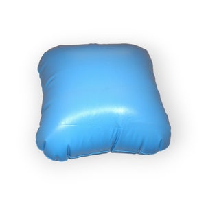 May include: A light blue inflatable pillow with a smooth, shiny surface. The pillow is rectangular and has rounded corners.