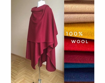 May include: A burgundy wool poncho with a cowl neck. The poncho is draped over a mannequin and is shown against a background of fabric swatches in various colors. The fabric swatches are labeled "100% Wool".