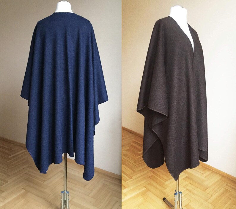 May include: Two wool ponchos, one navy blue and one brown, displayed on mannequins. The ponchos are draped over the mannequins and have a simple, elegant design.